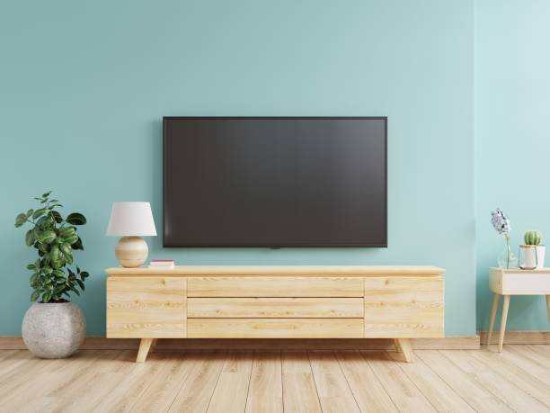 Mockup a TV wall mounted in a living room room with a blue wall.3d rendering